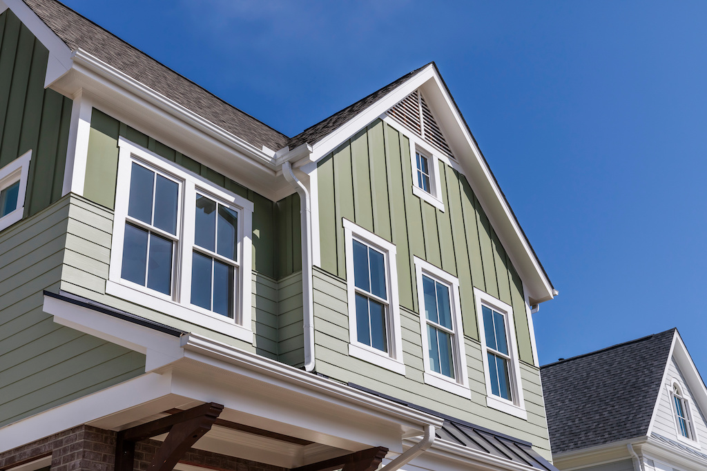 outside view of green residential home with custom windows with white trim