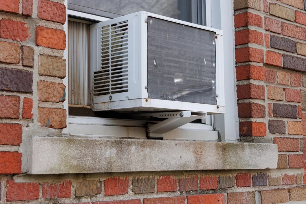 close up of brick home with ac unit installed in window