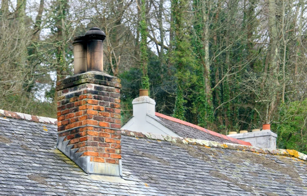 bad chimney flashing-chimney on a roof with debris and moss
