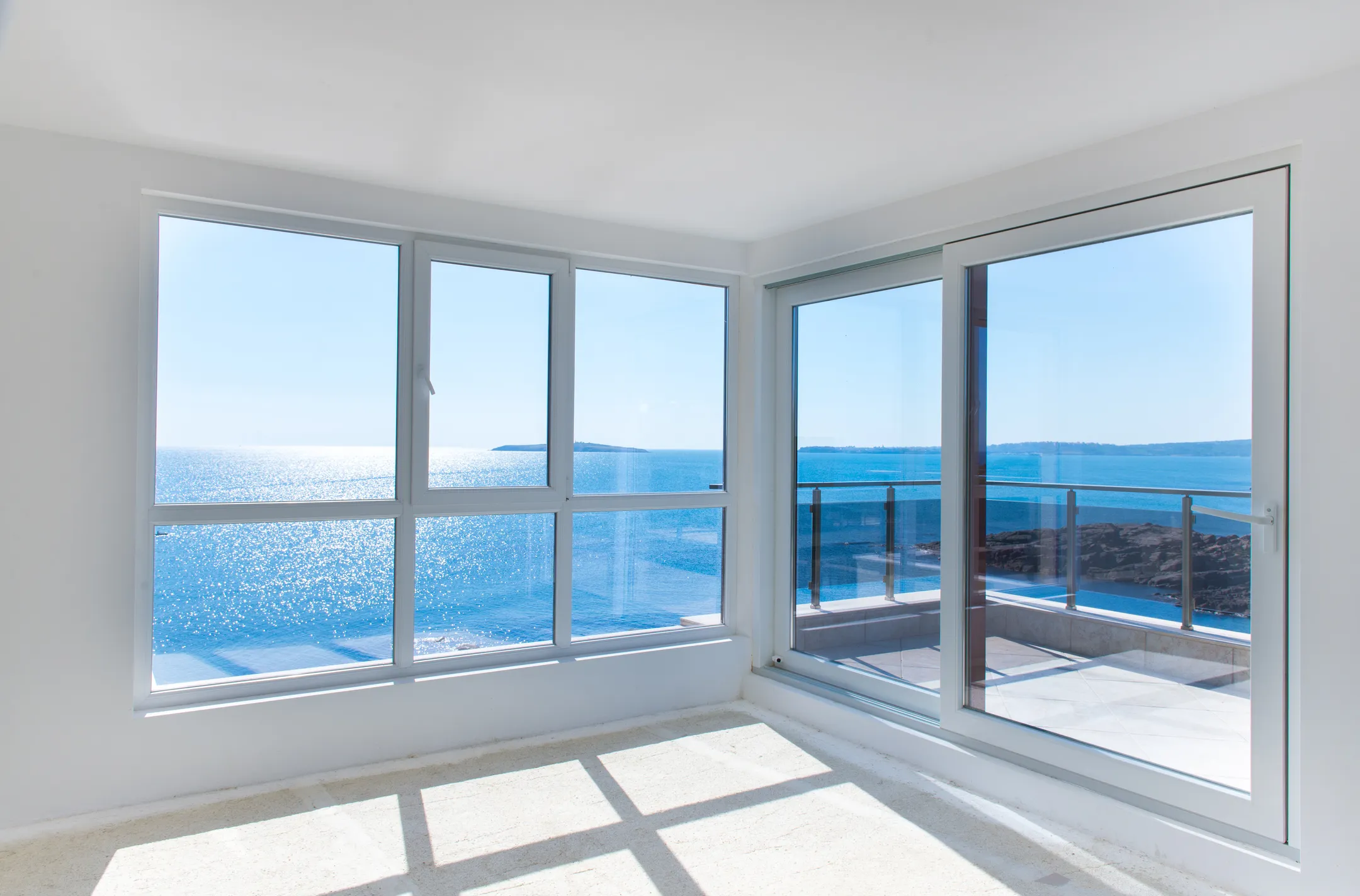 a room with large windows and a view of the ocean-window replacement cost