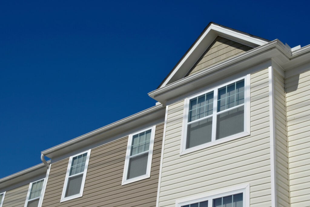 vinyl vs aluminum windows-vinyl windows on a the side of a home with multi colored siding