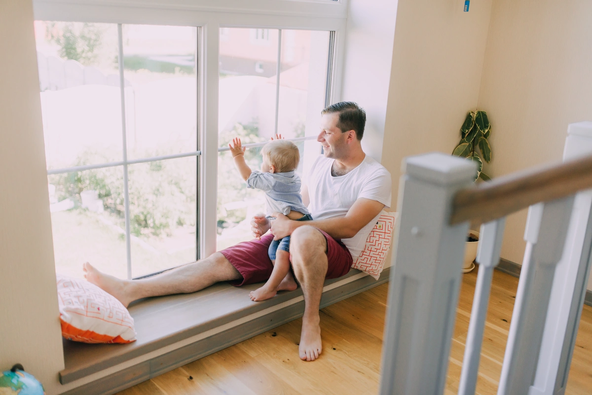 father and son sitting by the window