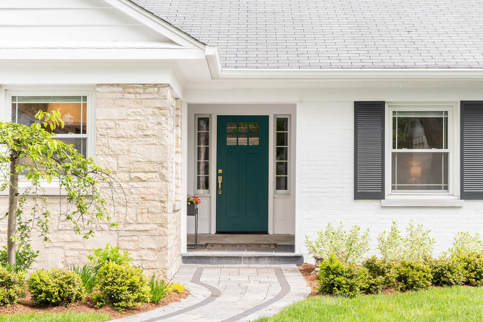 how to pick a front door color-white brick house with a dark green front door