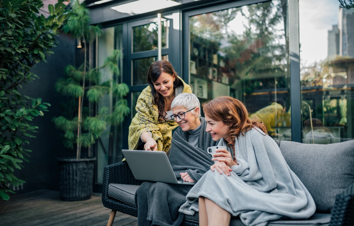 family sitting in their garden looking at computer