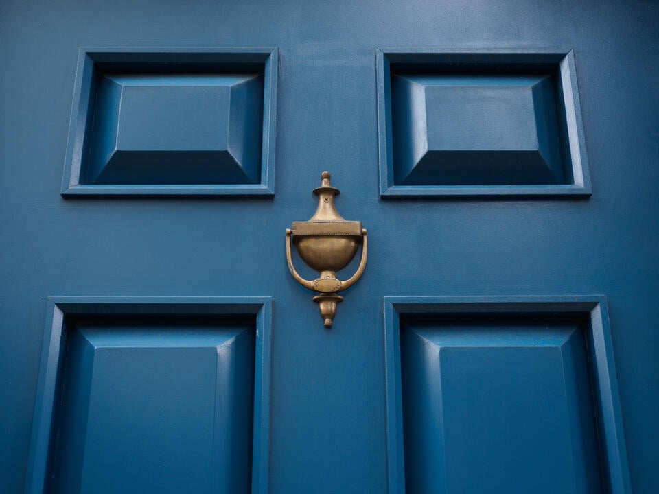 how to paint a fiberglass door-close up of a front door painted blue with a gold knocker