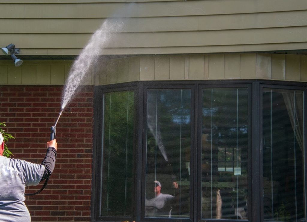 person cleaning vinyl siding