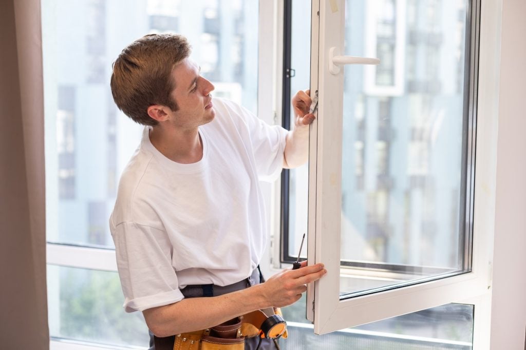a repairman repairs, adjusts or installs metal-plastic windows in the apartment. glazing of balconies, loggias, verandas in house. production of double-glazed windows to individual sizes. triple pane windows
