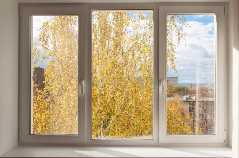 New white window overlook autumn yellow trees and clody sky