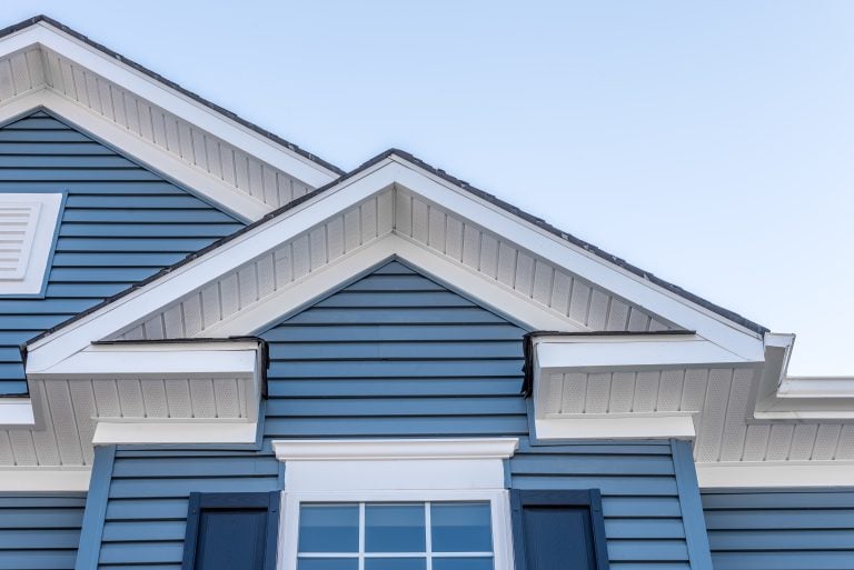 cedar siding boards Decorative gable roof with white cornice, blue horizontal vinyl