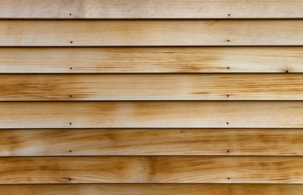 cedar siding boards Horizontal rows of cedar wood siding as an exterior wall in early morning light.