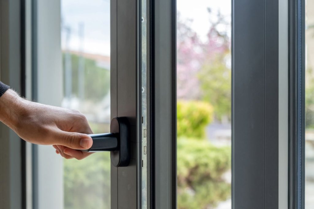 hand opening a black metal door