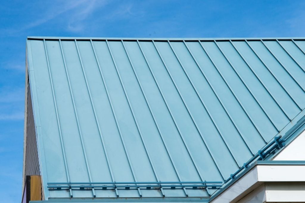 blue metallic sustainable roofing white wall blue sky snow guards