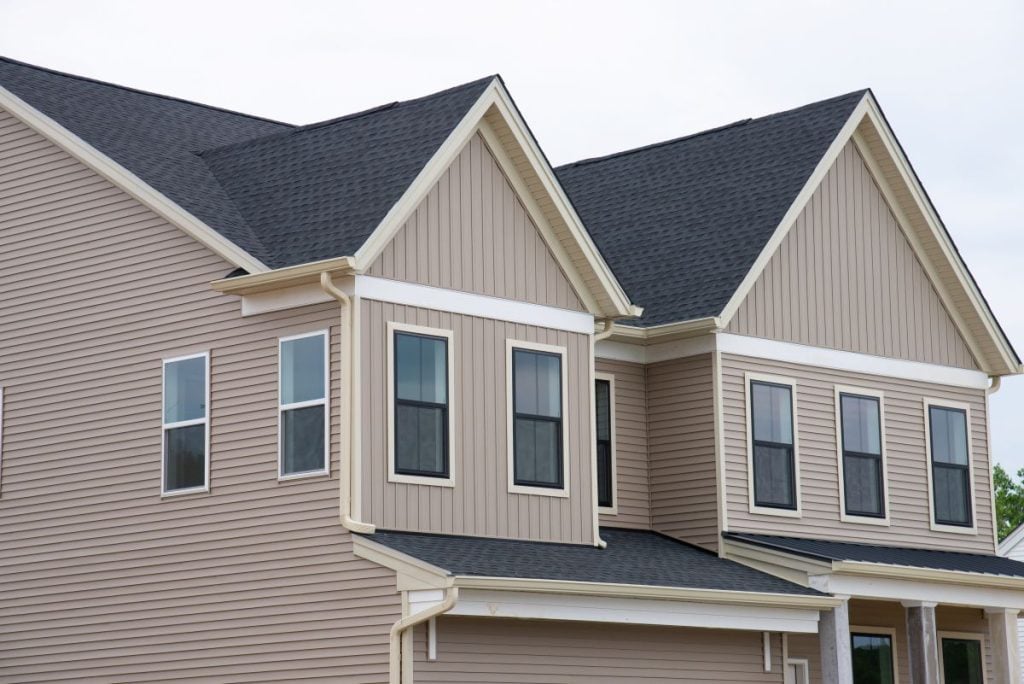 dark grey shingles roof installation huge home light brown slidings