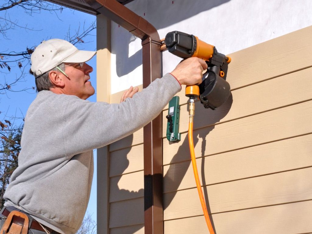 fiber cement siding mature worker using nail gun