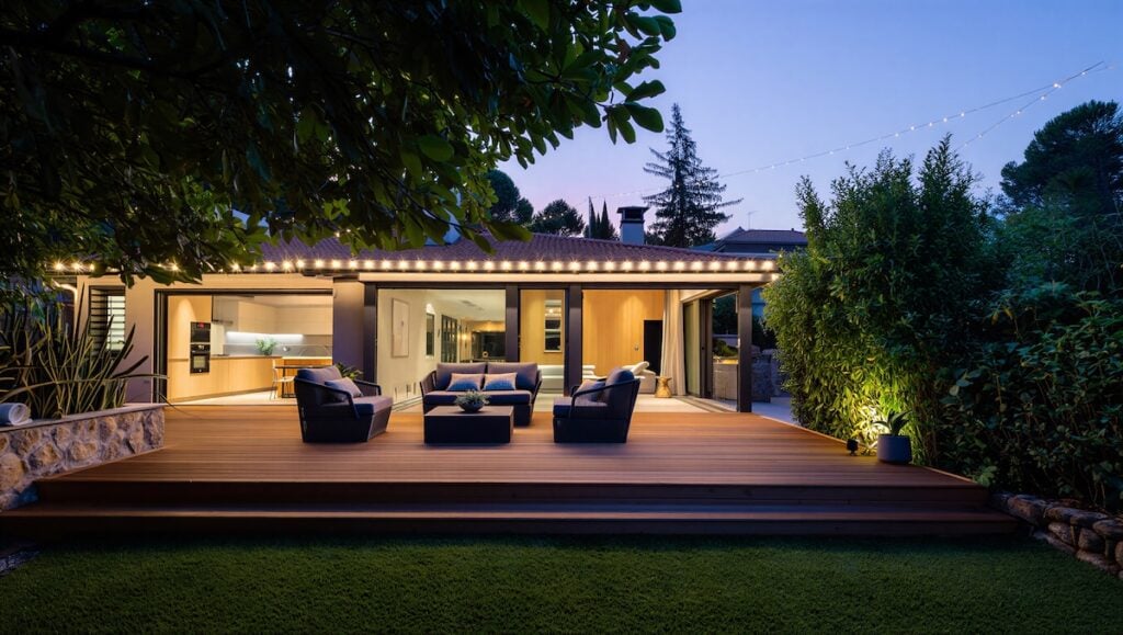 deck lighting ideas Warmly lit outdoor patio area of a house at dusk or evening